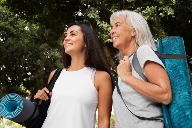 Amigas de diferença de idade se encontrando para ioga ao ar livre