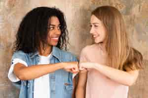 Foto grátis amigas sorridentes a bater os punhos