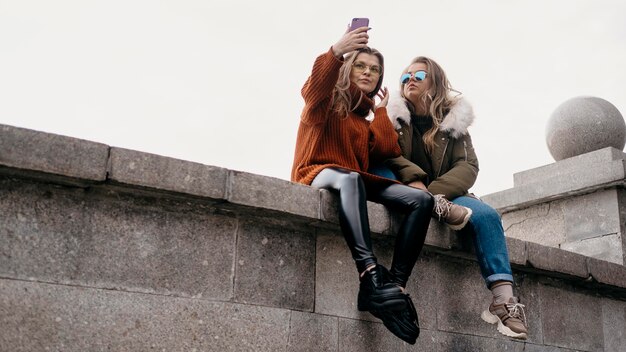 Amigas tirando selfie ao ar livre