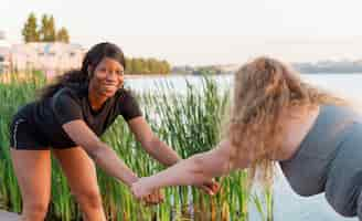 Foto grátis amigas treinando juntas no lago