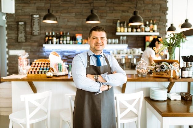 Foto grátis amigável barman com braços cruzados