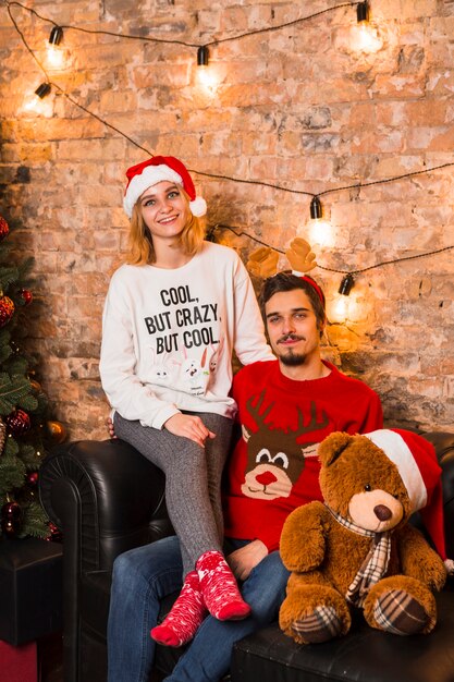 Amigável casal comemorando natal com ursinho