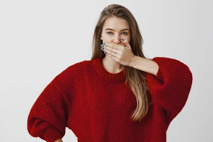 Foto grátis amigo jura não dizer palavra sobre segredo. retrato de mulher feminina bonita camisola solta na moda, cobrindo a boca com a palma da mão, prometendo manter o silêncio