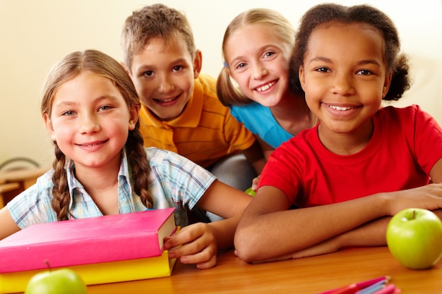 Amigos alegres que sentam-se na sala de aula