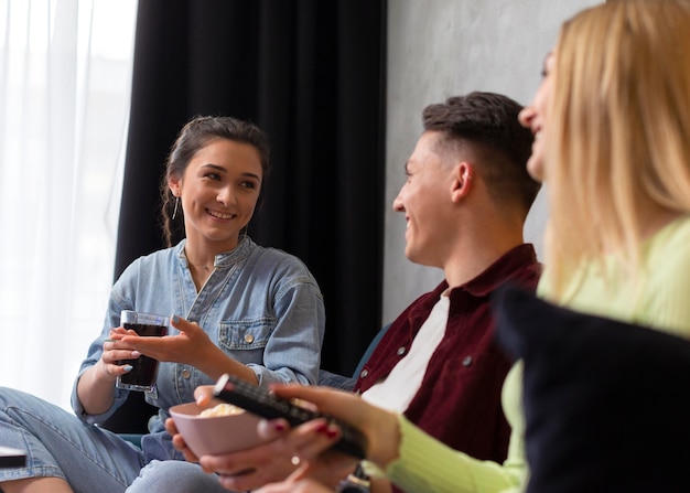 Amigos assistindo serviço de streaming juntos dentro de casa