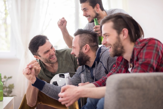 Foto grátis amigos bebendo cerveja e assistindo jogo de futebol