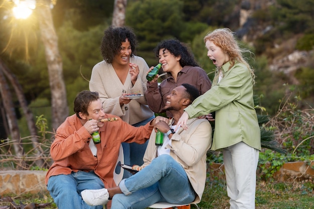 Amigos bebendo cerveja e conversando durante a festa ao ar livre