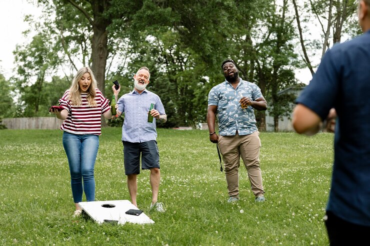 Foto grátis amigos brincando de cornhole em uma festa de verão no parque