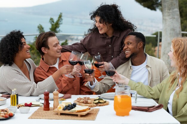 Amigos brindando com taças de vinho durante a festa ao ar livre