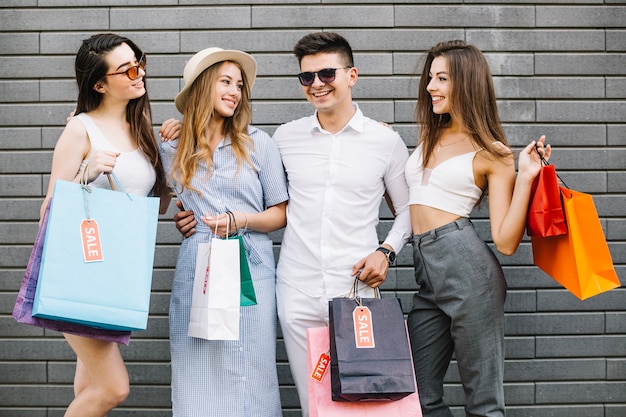 Amigos com sacos de papel abraçando