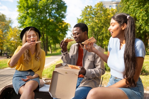 Foto grátis amigos comendo ao ar livre plano médio