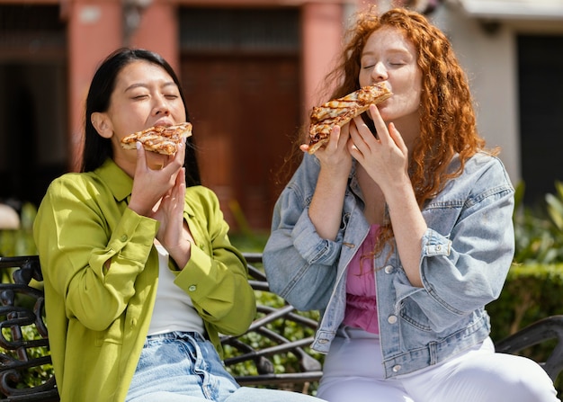 Amigos comendo comida de rua juntos