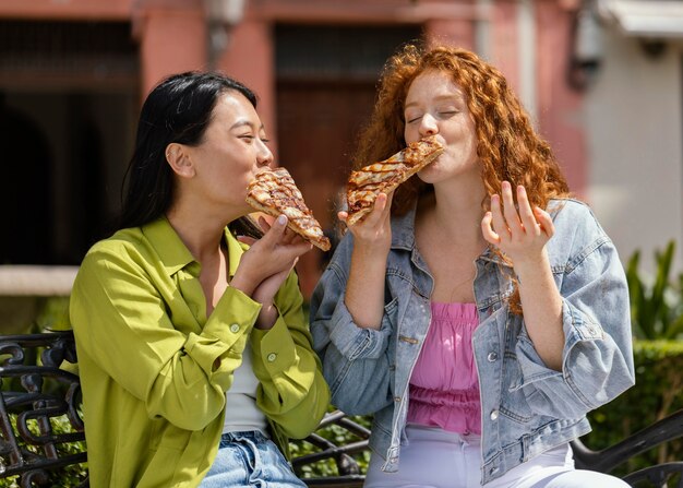 Amigos comendo comida de rua juntos