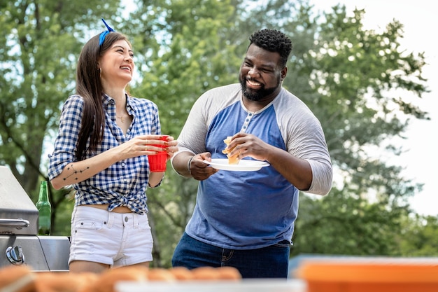 Amigos comendo hambúrgueres em uma festa ao ar livre