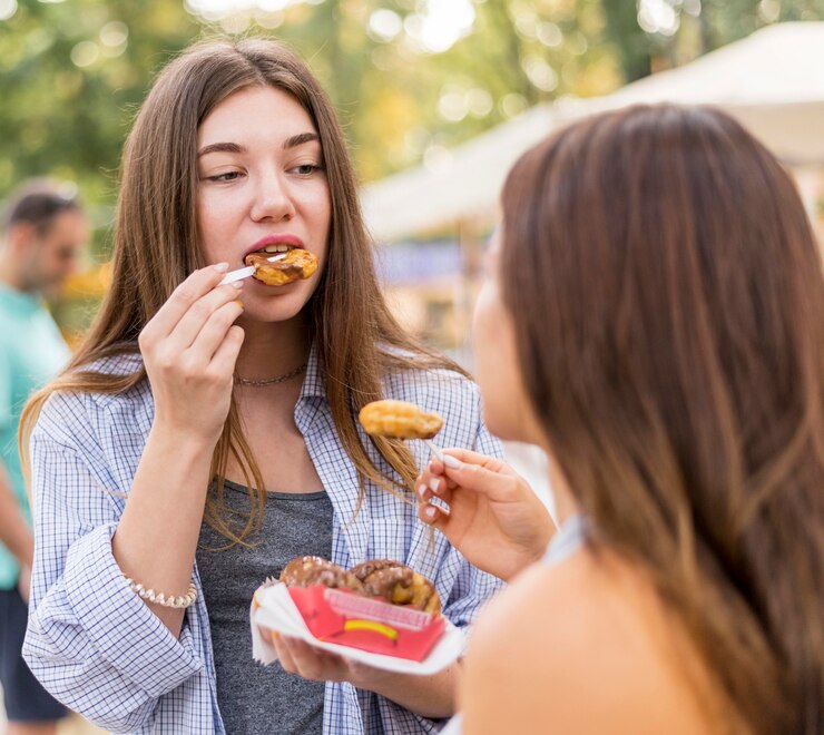 Foto grátis amigos comendo no parque de diversões
