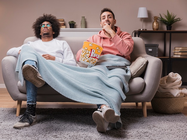 Foto grátis amigos comendo pipoca e assistindo filme