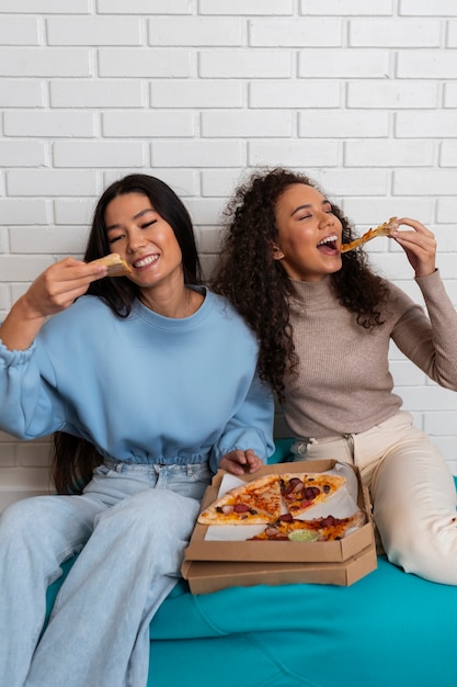 Amigos comendo pizza juntos em casa