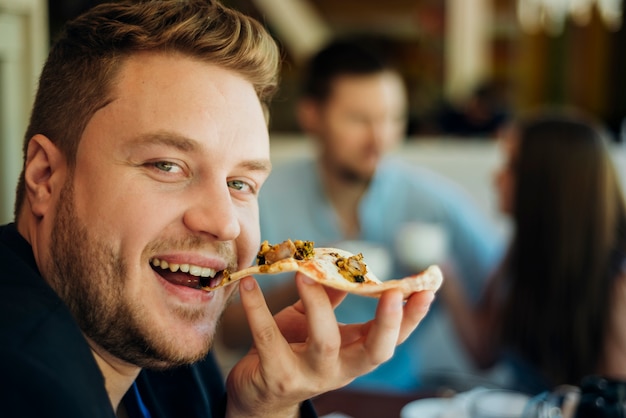 Amigos, comendo pizza, sentando, em, café