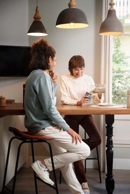 Foto grátis amigos completos sentados à mesa