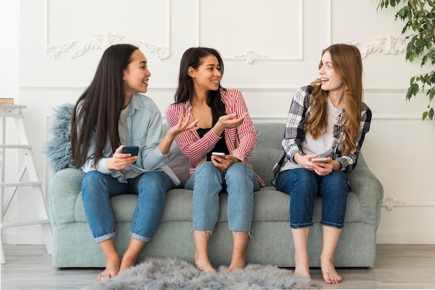 Amigos comunicar sentado no sofá