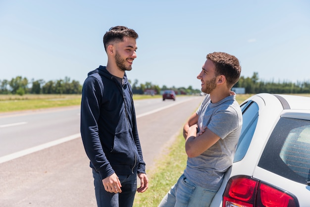 Amigos conversando ao lado da estrada