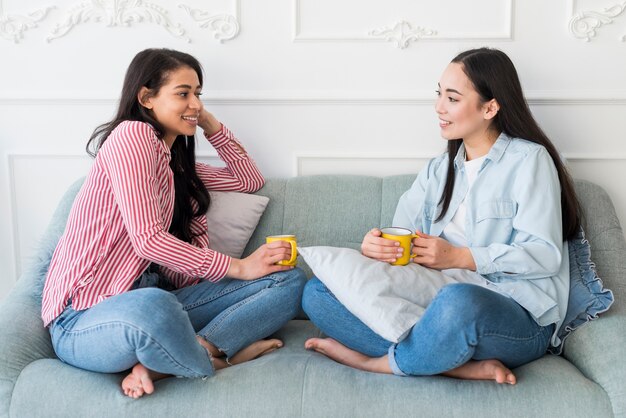 Amigos, conversando, enquanto, sentar sofá