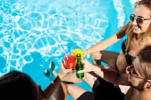 Foto grátis amigos conversando, sorrindo, bebendo coquetéis, descansando, relaxando perto da piscina