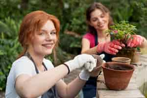 Foto grátis amigos cuidando de suas plantas em uma estufa