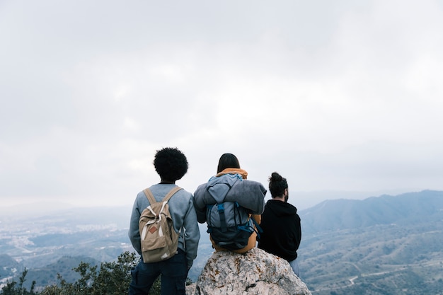 Amigos de alpinista bem sucedidos apreciar a vista no pico da montanha