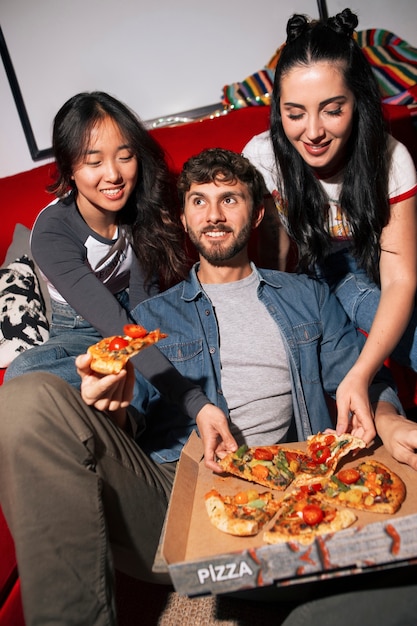 Amigos de alto ângulo a comer pizza.