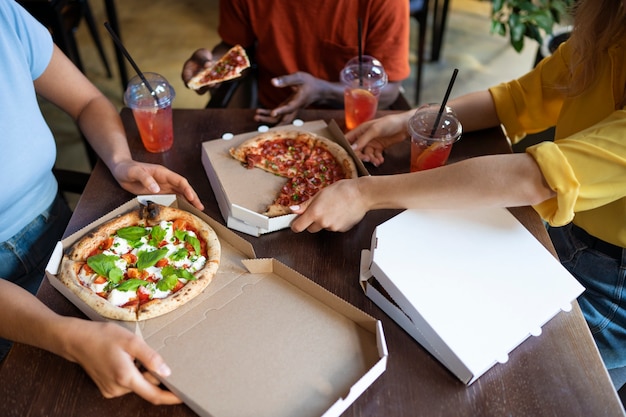 Amigos de alto ângulo comendo pizza