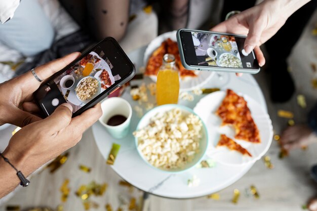 Amigos de alto ângulo tirando fotos de comida com smartphones