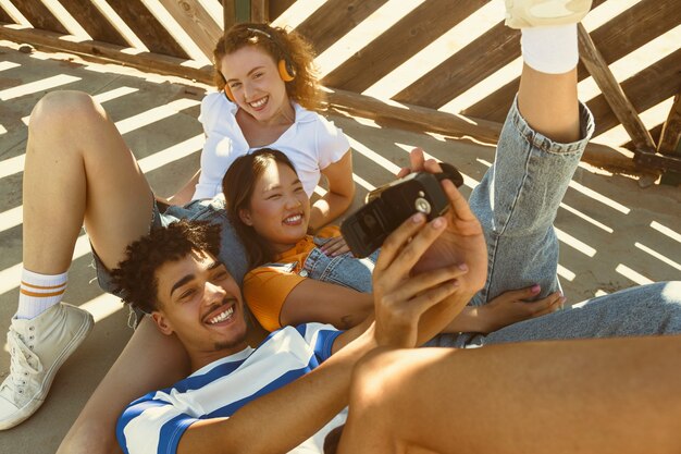 Amigos de alto ângulo tomando selfie com telefone antigo