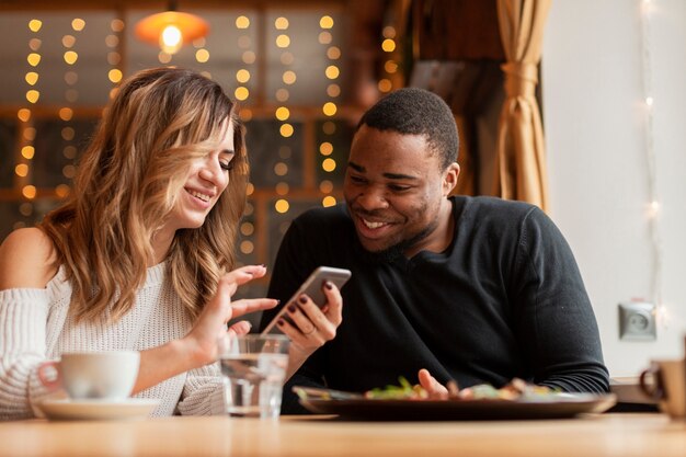 Amigos de baixo ângulo olhando no celular