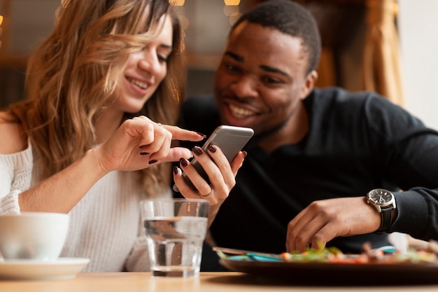 Amigos de baixo ângulo olhando no telefone