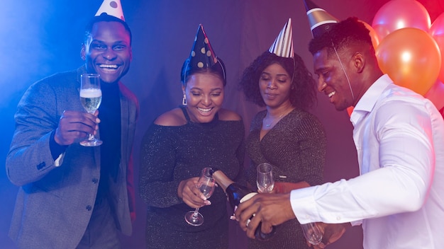 Amigos de frente usando chapéus de festa