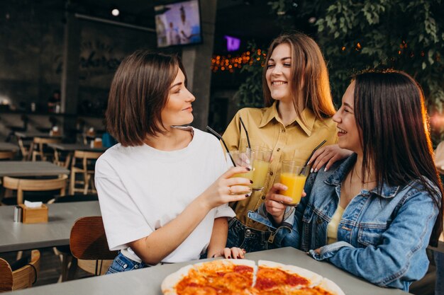 Amigos de menina com pizza em um bar na hora do almoço