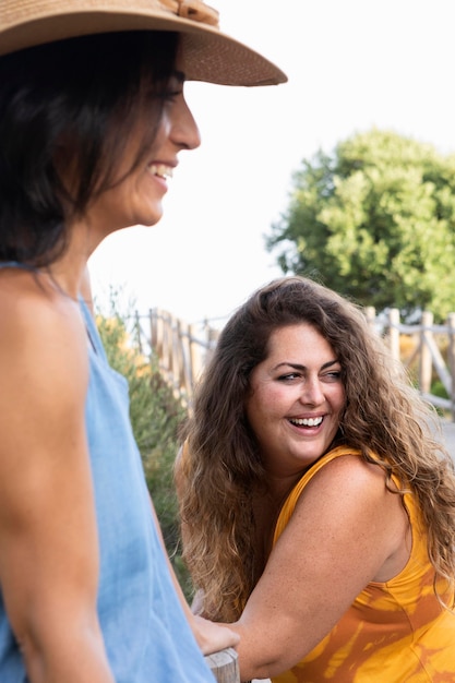 Amigos de mulheres sorridente juntos ao ar livre