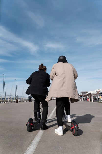 Amigos de tiro completo com scooters elétricos