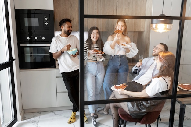 Amigos de tiro completo comendo pizza juntos