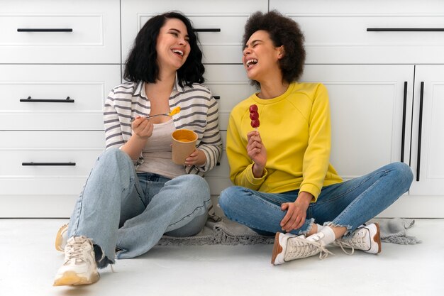 Amigos de tiro completo comendo sorvete dentro de casa