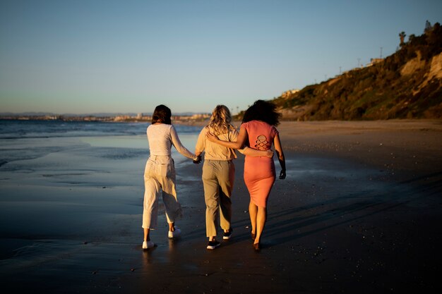 Amigos de tiro completo de mãos dadas à beira-mar