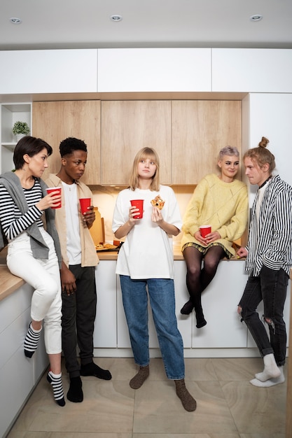 Foto grátis amigos de tiro completo segurando bebidas