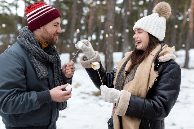 Amigos de tiro médio com marshmallows ao ar livre