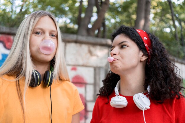 Amigos de tiro médio fazendo chiclete