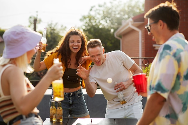 Amigos de tiro médio jogando beer pong