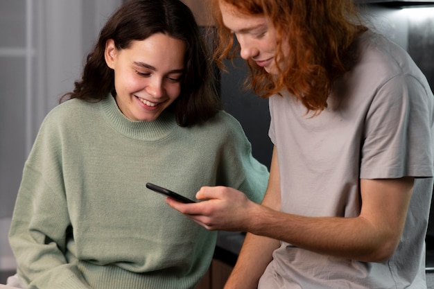 Amigos de tiro médio lendo mensagens de celular