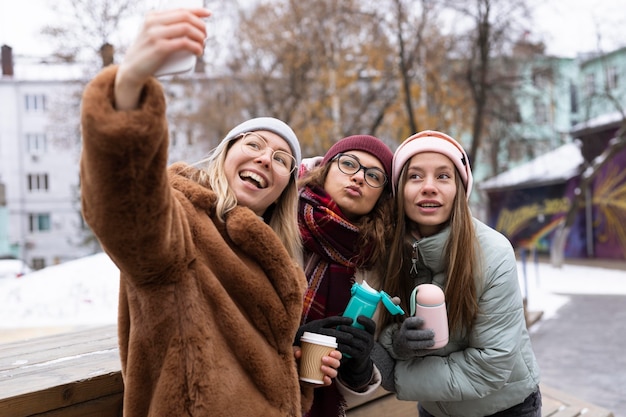 Foto grátis amigos de tiro médio tirando selfies