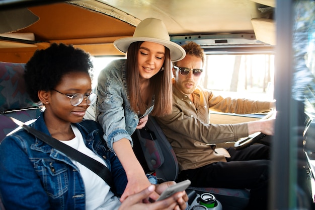 Amigos de tiro médio viajando na van