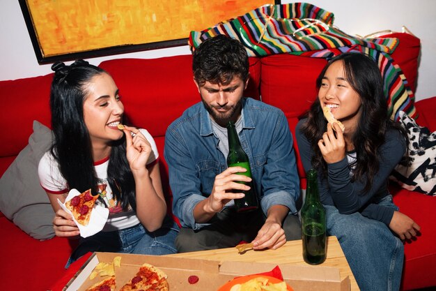 Amigos de tom médio a comer pizza.